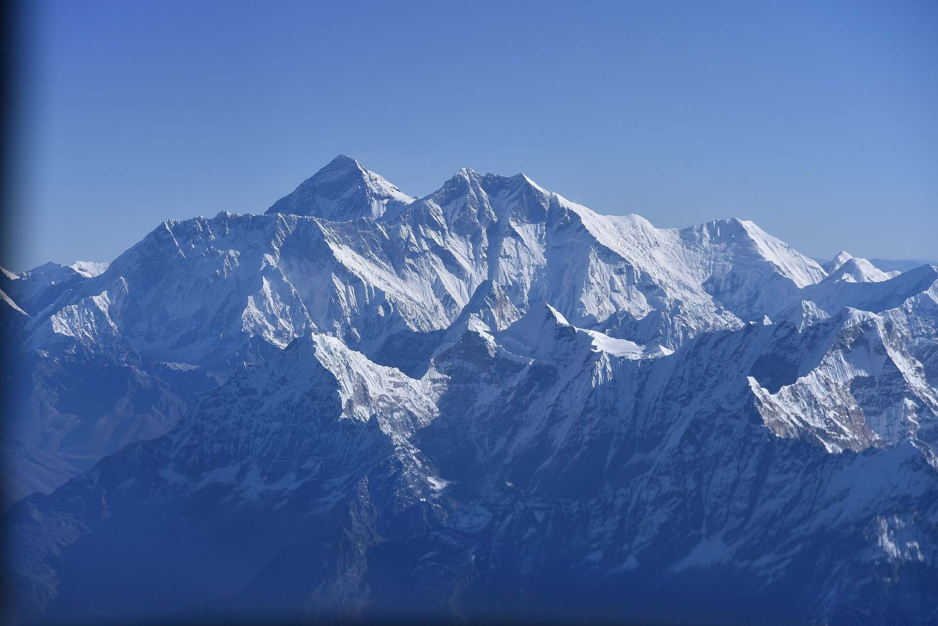 Sunrise on the high Himalaya, seen from the cabin of an aircraft in the cruise with the window frame around it.